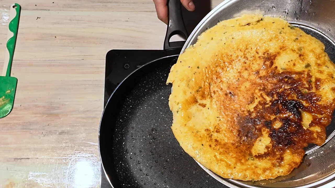 The golden-brown omelette slid from the lid back into the pan