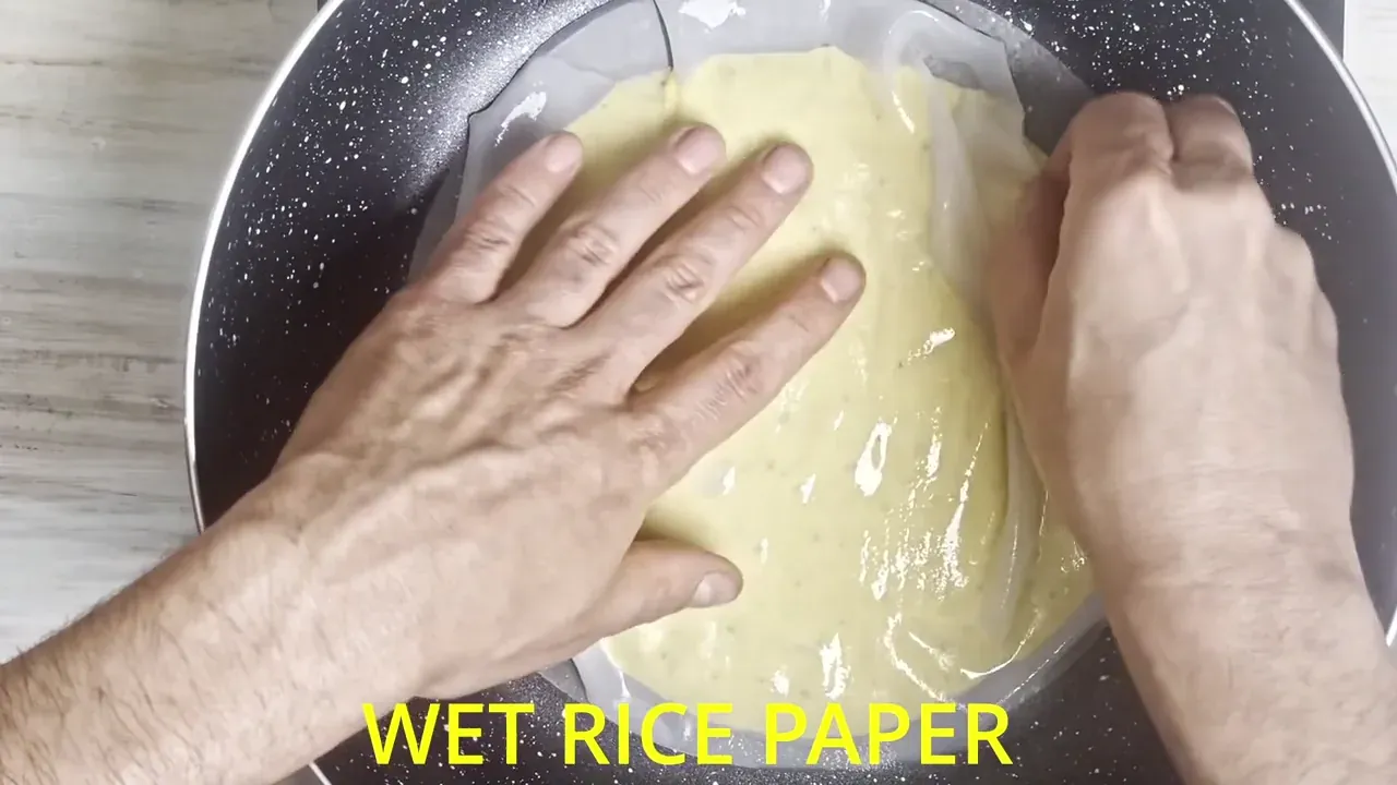 Place the pan over low-to-medium heat. While the base sets, quickly dip a second rice paper sheet in cold water for 10 seconds and gently press it onto the uncooked top surface.