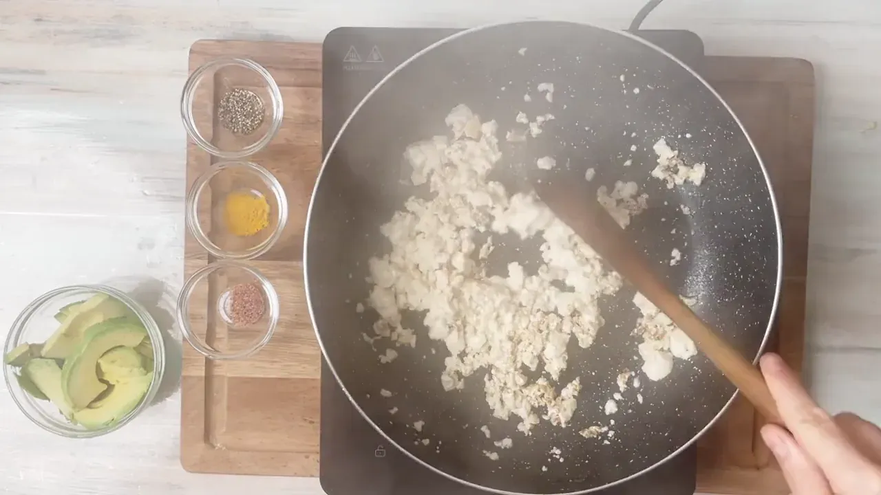 Break the tofu into curds with a wooden spoon as it cooks. After 6 to 8 minutes, the excess water will evaporate and the curds will brown lightly.