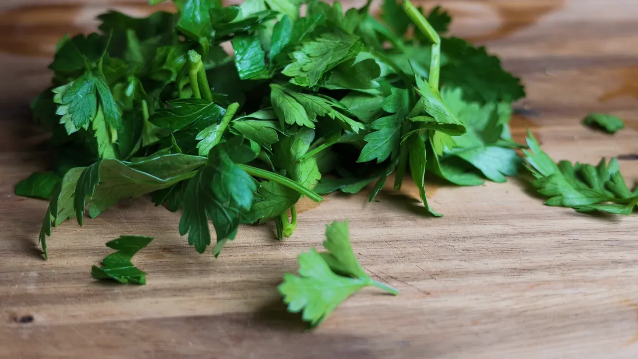 Close-up of finely chopped fresh parsley on a wooden board