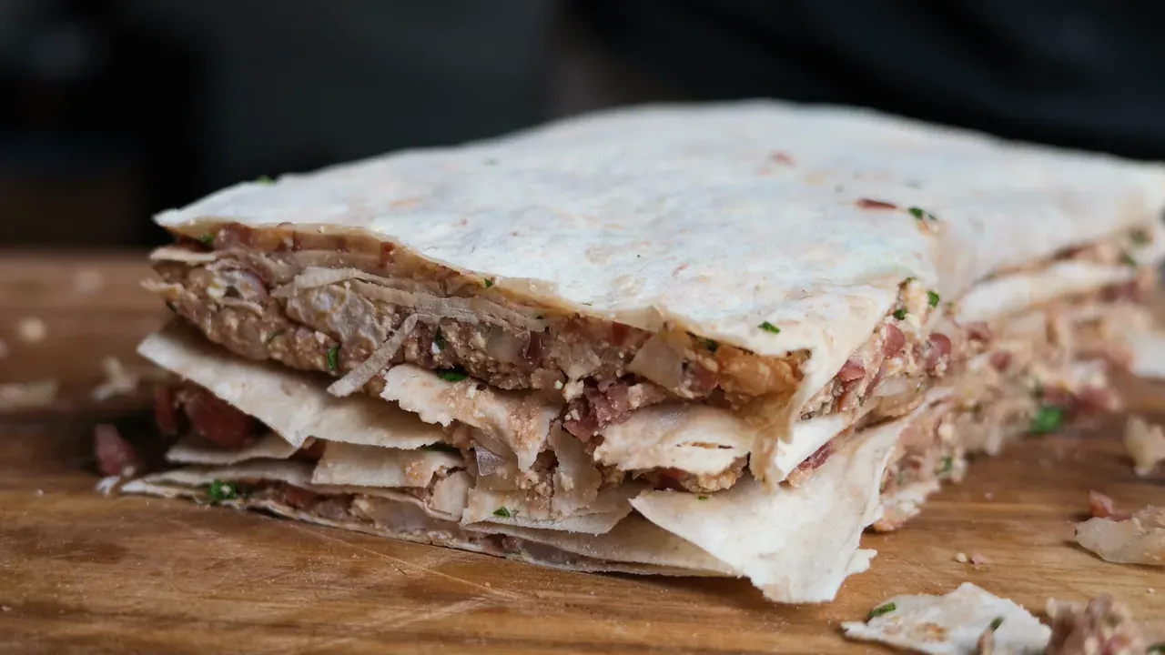 Side view of the stacked tortilla block with thin layers of bean and tofu filling