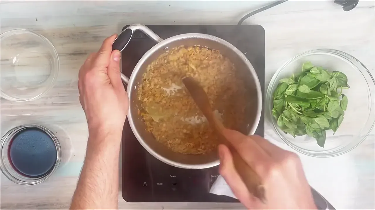Add the dried soy mince granules straight into the pot with the hot oil and aromatics. Stir continuously for 2 minutes to toast the granules and infuse them with olive oil.