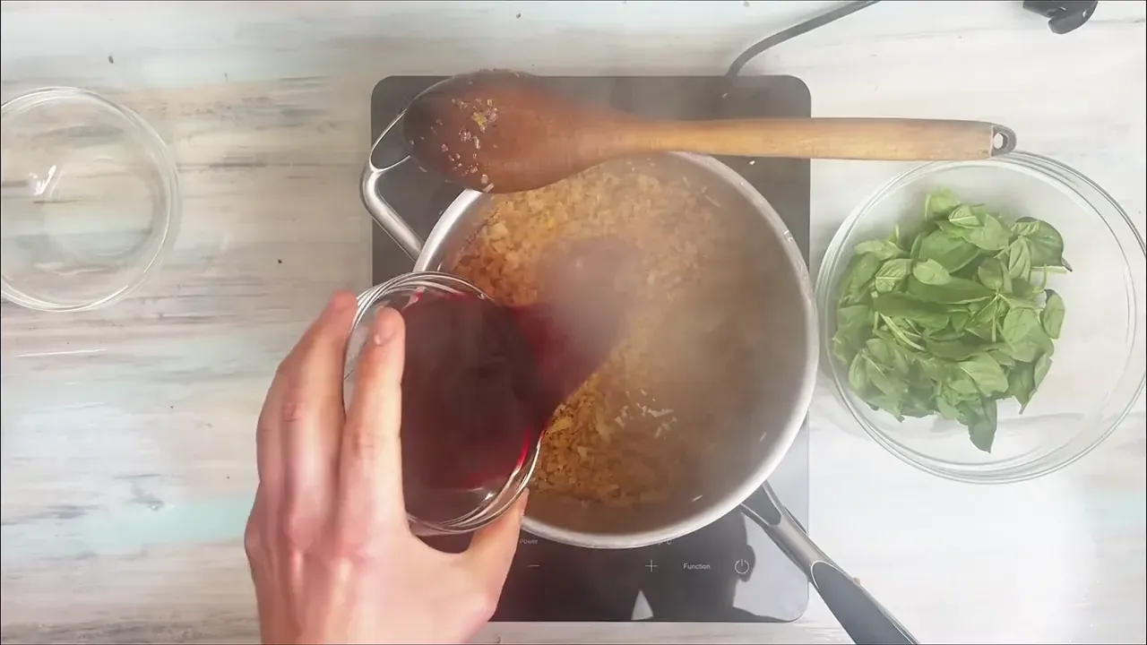 Pour in the red wine, stirring well to deglaze the bottom of the pot. Let it bubble vigorously for 2 to 3 minutes until the alcohol scent dissipates and the liquid reduces.