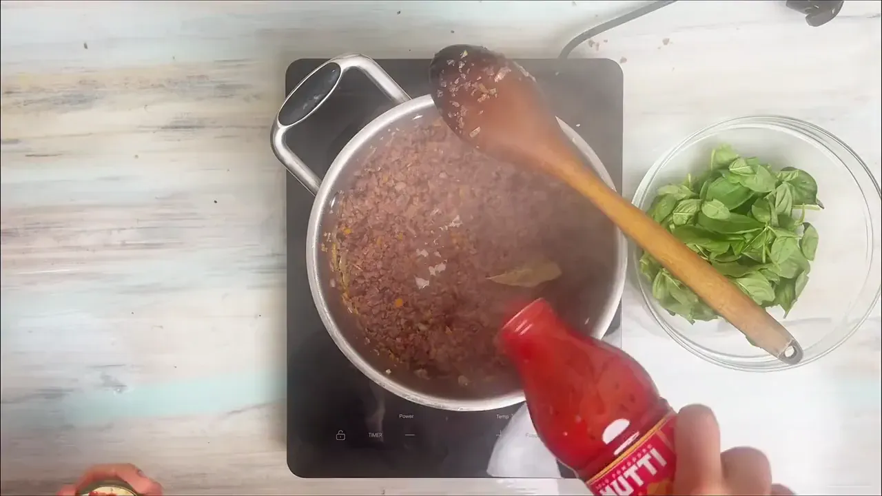 Pour in 750g of tomato passata, then rinse the empty passata bottle with 100ml of water and add that to the pot as well.