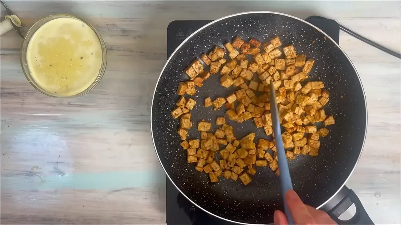 Scaldo una padella capiente a fuoco medio e faccio rosolare il tempeh per 8-10 minuti, mescolando ogni tanto, finché diventa ben brunito e croccante sui bordi. Lo lascio nella padella.