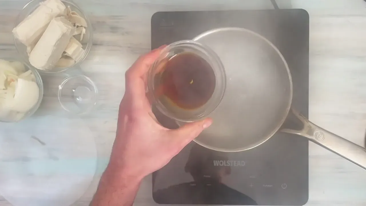 Porto a leggero bollore l'acqua in una casseruola, sciolgo il mezzo dado vegetale e unisco la salsa di soia.
