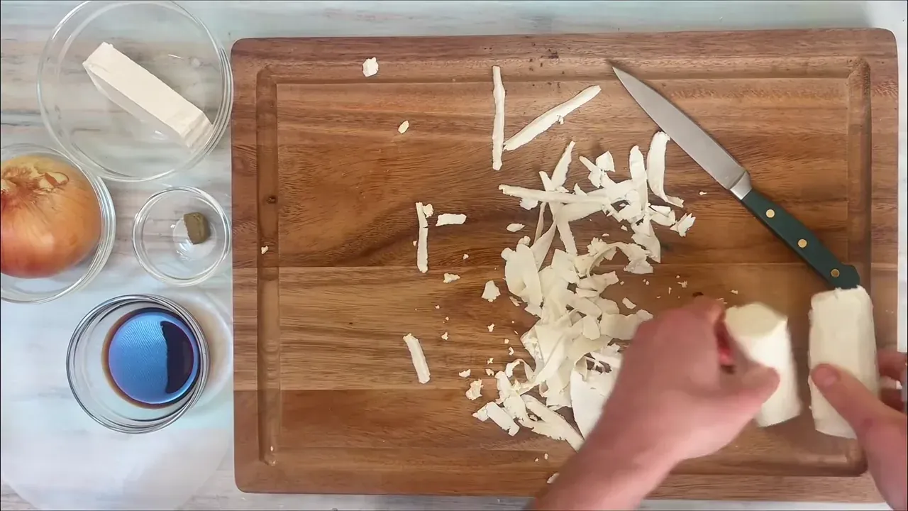 Con un pelapatate sfilaccio il panetto di tofu compatto ricavando nastri sottili e allungati.