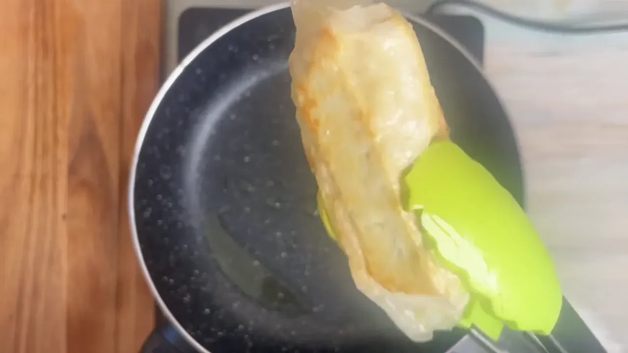 Scaldo l'olio in una padella a fuoco medio e faccio rosolare i wurstel per 5-7 minuti girandoli spesso, finché la carta di riso è dorata, gonfia e croccante.