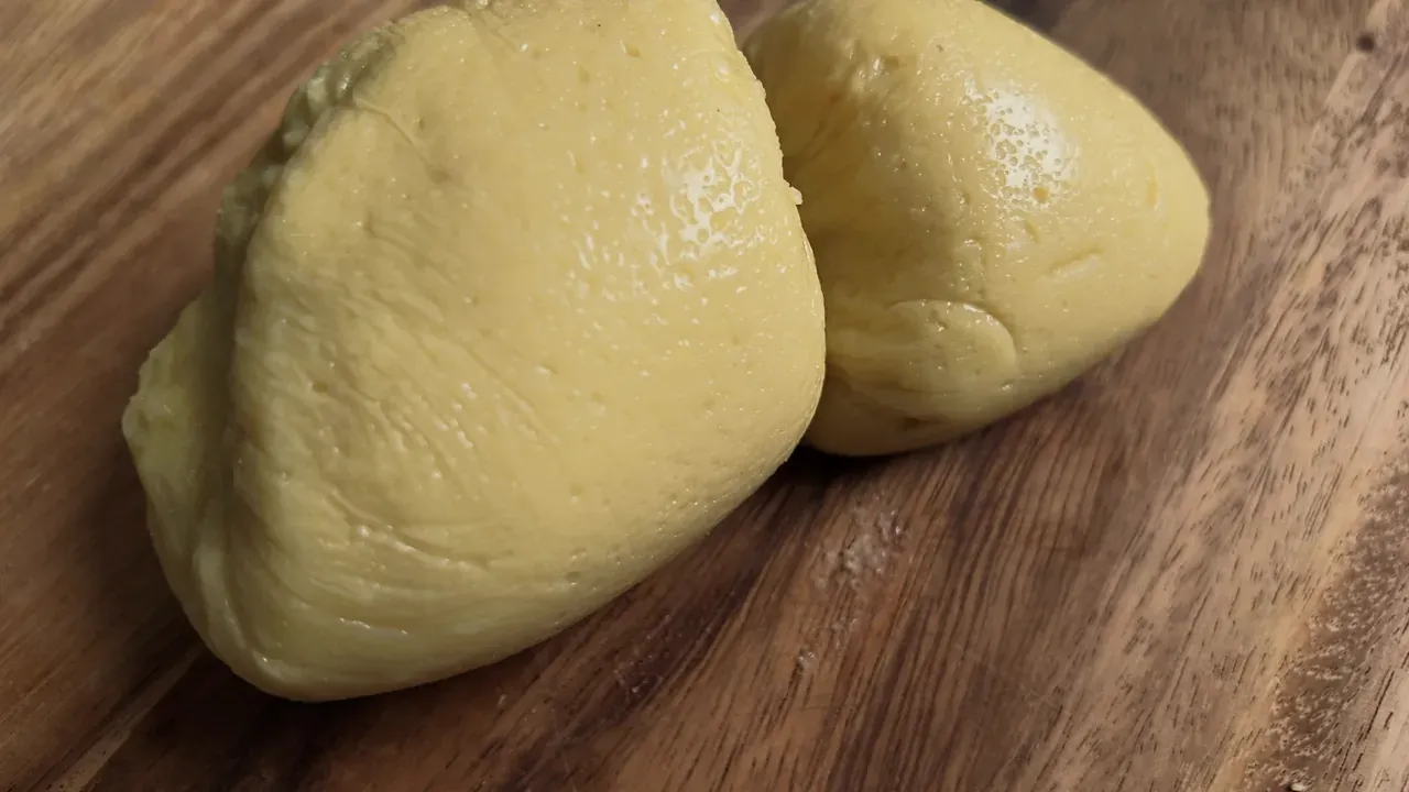 The set cheese, unwrapped, on a wooden board after chilling