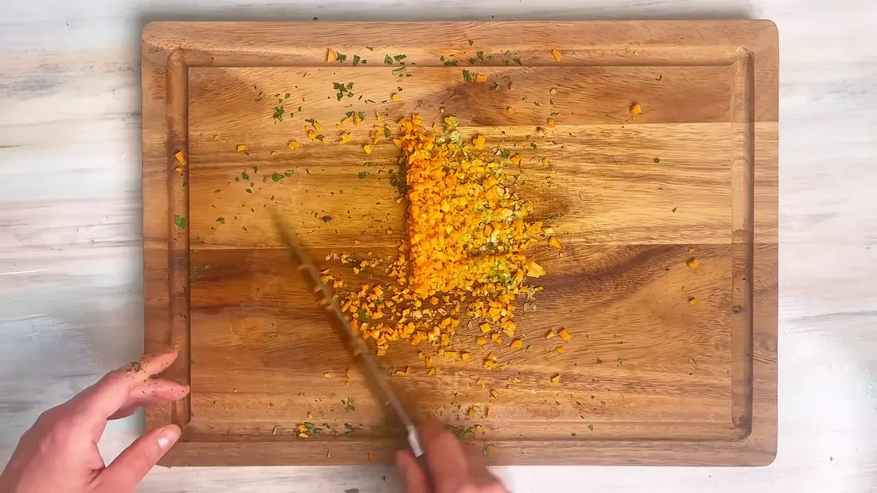 Finely mince the parsley, celery, carrot, and yellow onion on a cutting board until very fine.